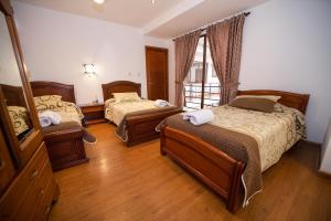 a hotel room with two beds and a window at Hotel Casa del Barranco in Cuenca