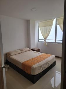 sypialnia z łóżkiem i oknem w obiekcie Apartamento FL Martinz w mieście Manizales