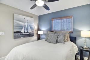 een slaapkamer met een wit bed en een plafondventilator bij Unit B 3bd2ba Condo, Steps To The Sand & Pier! in Newport Beach