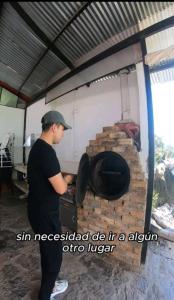 un hombre de pie junto a un horno de ladrillo en Hermosa Finca El Porvenir, en Tibasosa