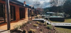 a building with a garden in front of it at Savvanah Farmstay family friendly home with stunning views and spa in Chum Creek