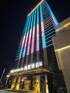 un edificio con luces de colores en el costado. en TRUE Go hotel, en Chengdú