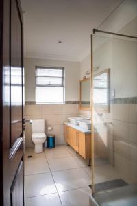 a bathroom with a toilet and a sink and a shower at Unit 14, Capella Place in East Legon