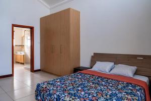 um quarto com uma cama e um armário de madeira em Unit 14, Capella Place em East Legon
