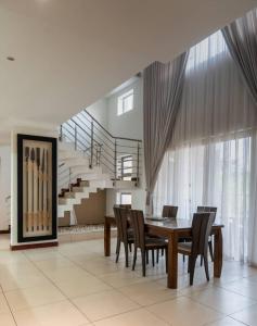 a dining room with a table and chairs and a staircase at Unit 14, Capella Place in East Legon