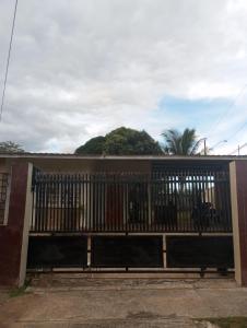 Hostal EL VALLE في Los Algarrobos: بوابة امام مبنى فيه جبل في الخلف
