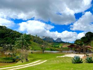 Pousada Rural Recanto do Lago في بيدرا أزول: حديقة بها بحيرة و شرفة