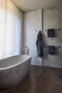 a bathroom with a large tub and towels at Villa Abrazos in San Pedro