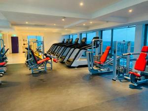 a gym with treadmills and machines in a building at Golden Tree Hotel Belize in Belize City