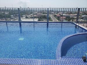 a large swimming pool with blue water at Golden Tree Hotel Belize in Belize City