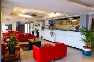 伯利茲城的住宿－Golden Tree Hotel Belize，一间设有红色椅子和柜台的等候室