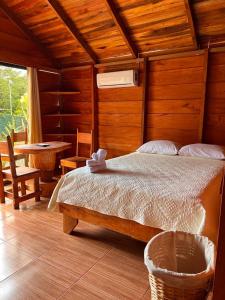 1 dormitorio con 1 cama en una habitación con mesa en Cabañas SyC, en Fortuna