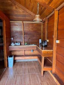 una cocina con fregadero en una cabaña de madera en Cabañas SyC, en Fortuna