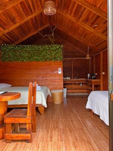 a room with two beds and a table and chairs at Cabañas SyC in Fortuna