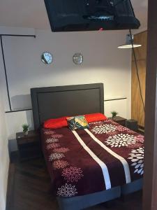 - une chambre avec un lit et une couette marron et blanche dans l'établissement Floresta I, II, III y IV Bed and Breakfast, à Santiago