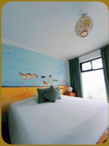 ein Schlafzimmer mit einem weißen Bett und einem Gemälde an der Wand in der Unterkunft Suites+Arte in Quito