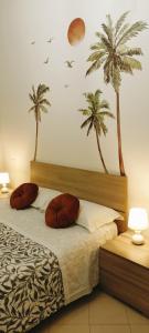 Schlafzimmer mit einem Bett mit Palmen an der Wand in der Unterkunft F.A.M. ROOMS in Ciampino