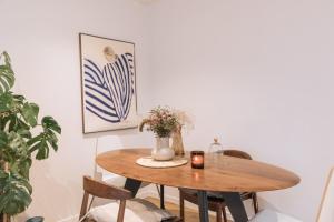 a dining room table with a candle and a vase at Beautiful 1BD Apartment Issy-les-Moulineaux! in Issy-les-Moulineaux