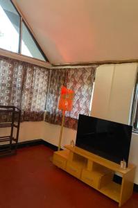 a living room with a flat screen tv and a lamp at Cottage in Arusha-Wanderful Escape in Arusha