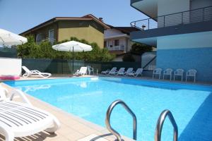 - une piscine avec des chaises et une table dans l'établissement Villa Bruna, à Lignano Sabbiadoro