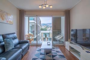 a living room with a couch and a large window at Madalenas View in Funchal