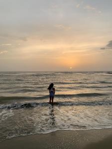 Dziewczyna stojąca w wodzie na plaży w obiekcie Cabaña Coralina Casa Playa w mieście Juan de Acosta