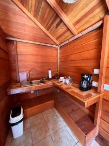 a kitchen with a sink in a wooden cabin at Cabañas SyC in Fortuna