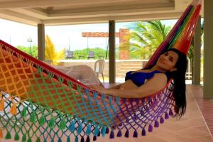 a woman is laying in a hammock at Cabaña Coralina Casa Playa in Juan de Acosta