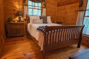 1 dormitorio con 1 cama en una cabaña de madera en The Pines Riverside Log Cabin On The Ocoee, en Ocoee