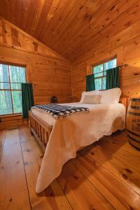 1 dormitorio con 1 cama en una cabaña de madera en The Pines Riverside Log Cabin On The Ocoee, en Ocoee
