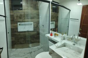 a bathroom with a shower and a toilet and a sink at Casa Nova Centro de Penedo-Quitinete in Penedo