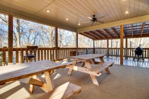 Bull ShoalsにあるCozy Bull Shoals Condo Getaway about 1 Mi to Lake!のピクニックテーブルと天井扇風機を備えた網戸付きポーチ
