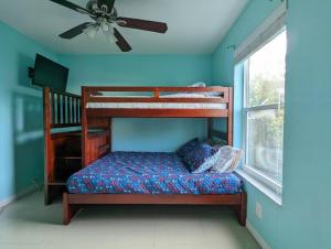 a bedroom with a bunk bed and a ceiling fan at Mint Home of Siesta Key's 3/2 & Serene Patio! in Sarasota