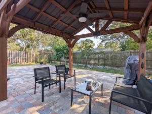 a patio with chairs and a wooden pergola at Mint Home of Siesta Key's 3/2 & Serene Patio! in Sarasota