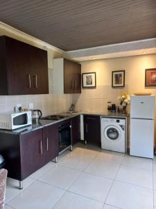 a kitchen with a washing machine and a washer at Angelmalatji guesthouse in Graskop