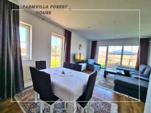 a living room with a white table and a couch at FarmVilla Forest House in Lipljan