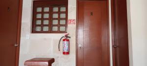 a fire extinguisher is on the wall next to a door at Bed and Breakfast Pecarí in Cancún