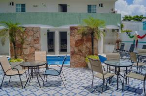 a patio with tables and chairs next to a pool at Hotel CEO Group in Campeche