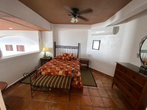 een slaapkamer met een bed en een plafondventilator bij one beach street hotel -Beach front Spacious 1BD 1BA fabulous view in Zona Romantic Puerto Vallarta in Puerto Vallarta +38 foto's