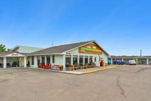 a building with tables and chairs in a parking lot at Badlands Motel in Drumheller