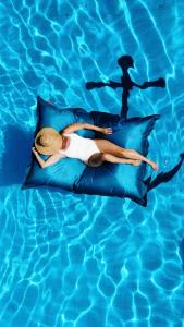 Una donna sdraiata su un cuscino in piscina di Captain Goodtimes a Gili Air