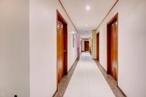 un pasillo de pasillos con puertas de madera y paredes blancas en Hotel Broadway, en Chandīgarh