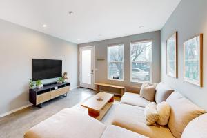 a living room with a couch and a flat screen tv at Luxury Ballard Townhome in Seattle