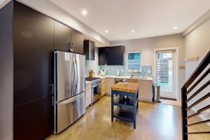 uma cozinha com um frigorífico de aço inoxidável e uma mesa em Luxury Ballard Townhome em Seattle