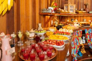 a buffet with fruit and drinks on a table at Pousada Boutique Vilage de Minas in Monte Verde