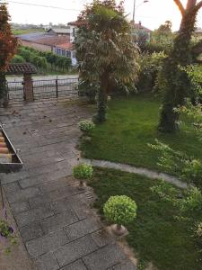 un jardin avec une passerelle en pierre avec des arbres et des plantes dans l'établissement LA CASA DI GIM, à Lugo