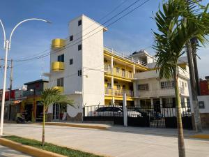 un edificio blanco con balcones amarillos en una calle en Hotel El almirante, en Tecolutla