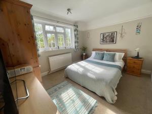 una camera da letto con un grande letto bianco e una finestra di Lavender Oaks Detached Country House a Purley