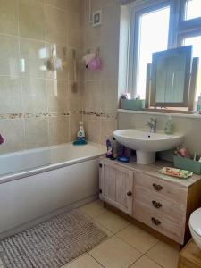 a bathroom with a sink and a tub and a toilet at Lavender Oaks Detached Country House in Purley