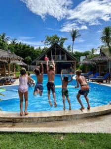 un grupo de niños saltando a una piscina en Captain Goodtimes, en Gili Air